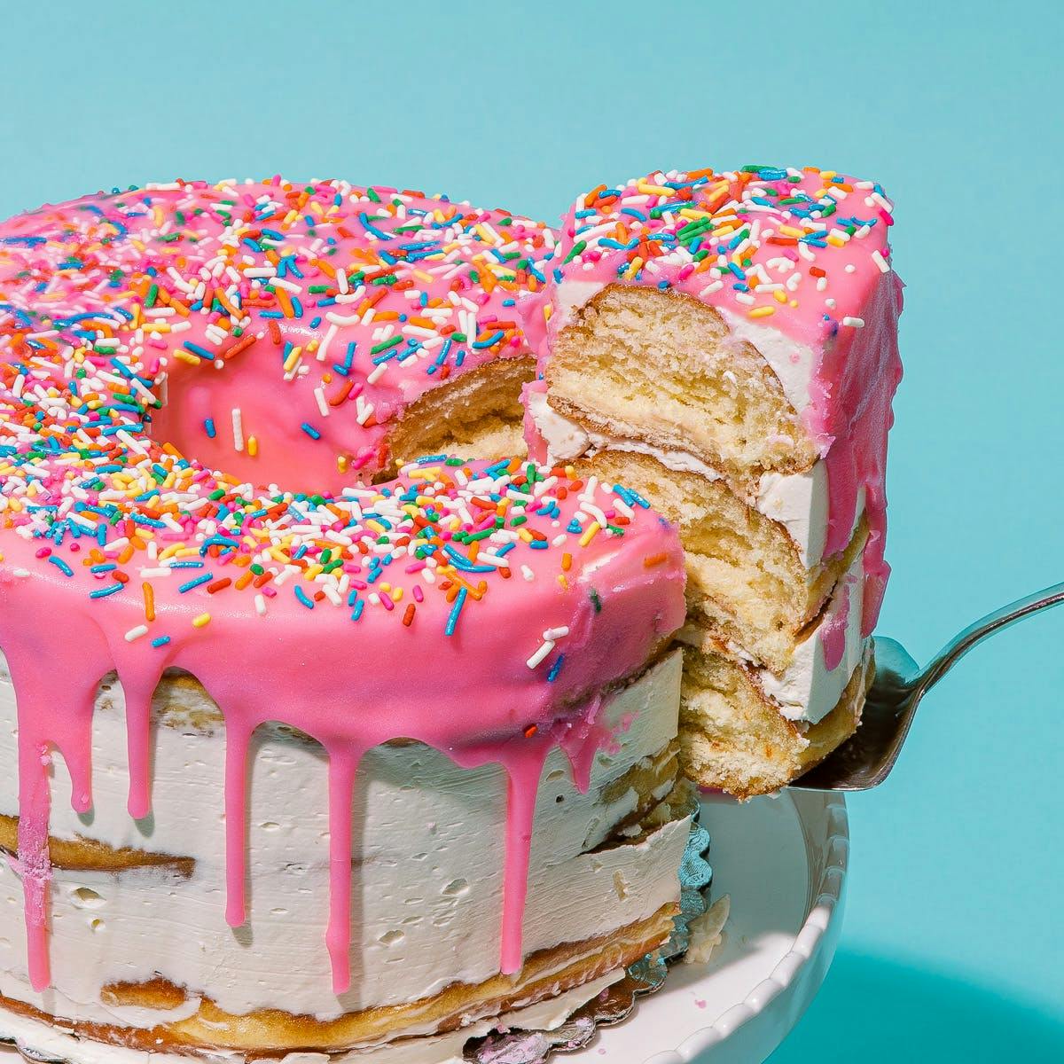 https://goldbelly.imgix.net/uploads/showcase_media_asset/image/94678/pink-jumbo-doh-nut-cake.9202049a38d2bd4678558f7d8c1b1df3.jpg?ixlib=rails-3.0.2